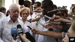 Former President Jimmy Carter, left, speaks with journalists as his wife Rosalynn looks on after visiting the Belen convent in Old Havana, Cuba, March 29, 2011