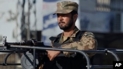 FILE - A Pakistan army soldier mans at a vehicle during a curfew in Rawalpindi, Pakistan on Saturday, Nov. 16, 2013.