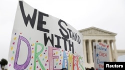 FILE - Demonstrators rally outside the Supreme Court as justices were scheduled to hear arguments in the consolidation of three cases regarding the Trump administration’s bid to end DACA, in Washington, Nov. 12, 2019.