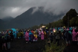 La gente observa el eclipse total de sol en las orillas del lago Villarrica en Pucón, sur de Chile, el 14 de diciembre de 2020.