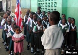 FILE - Liberian students are seen assembled to salute the flag at a Catholic school in the Liberian capital Monrovia.