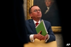 FILE - Acting White House chief of staff Mick Mulvaney listens in the Oval Office of the White House in Washington, Jan. 31, 2019.