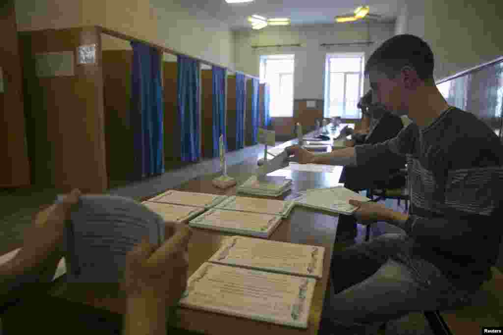 Election commission workers count ballots at a polling station ahead of Sunday's referendum in the eastern Ukrainian city of Slovyansk, May 10, 2014.