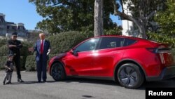 হোয়াইট হাউসের সামনে যুক্তরাষ্ট্রের প্রেসিডেন্ট ডনাল্ড ট্রাম্প টেসলার সিইও ইলন মাস্কের পাশে দাঁড়িয়ে মিডিয়ার সাথে কথা বলছেন। ১১ মার্চ, ২০২৫। 