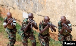 Somali government soldiers demonstrate their skills during their passing out ceremony at an army training camp in Uganda, Feb. 1, 2013.
