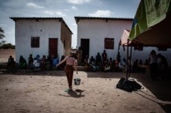 Villagers wait in line to be seen by a visiting gynecologist who traveled with American students from Lich-Wilmerding High School in San Francisco to the village of Guedj Martin, Senegal. (Annika Hammerschlag, for VOA)
