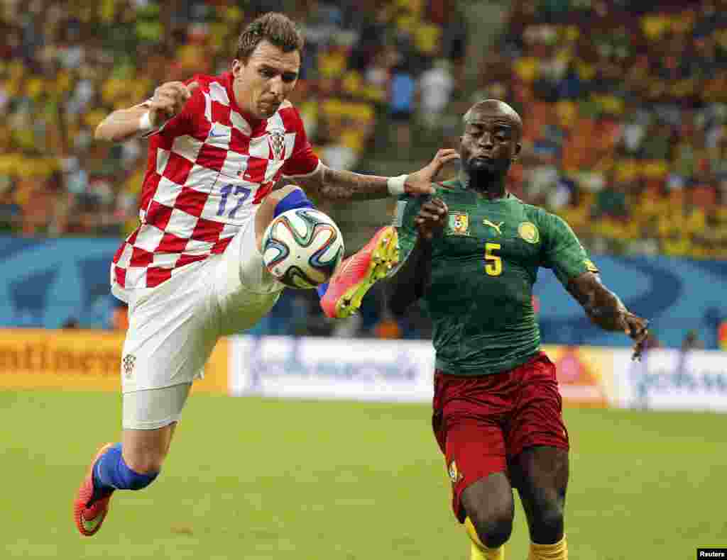Croatia&#39;s Mario Mandzukic (left) fights for the ball with Cameroon&#39;s Dany Nounkeu during their 2014 World Cup Group A soccer match at the Amazonia arena, in Manaus, June 18, 2014.