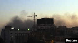 Asap mengepul di pusat kota Khartoum saat warga berunjuk rasa atas kematian empat mahasiswa di Darfur (9/12).