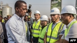 FILE - Zambian President Edgar Lungu, left, greets Chinese workers from Aviation Industry Corporation of China during a walk on a major road in Lusaka, Zambia, Sept. 15, 2018. 