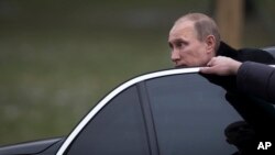 FILE - Russian President Vladimir Putin is seen getting out of his limousine in Moscow, Russia, Feb. 23, 2014.