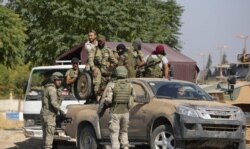 Turkish soldiers and Turkey-back Syrian fighters patrol the northern Syrian Kurdish town of Tal Abyad, on the border between Syria and Turkey, Oct. 23, 2019.