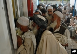 FILE - Afghan refugees living in Pakistan wait to get their documents to travel back to Afghanistan, at the UNHCR's Repatriation Center, in Peshawar, Pakistan, Sept. 7, 2016.