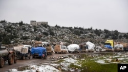 Syrian civilians flee from Idlib in rain toward the north to find safety inside Syria near the border with Turkey, Feb. 13, 2020. 