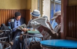 FILE - In this Oct. 10, 2016, photo, Ethiopian men read newspapers and drink coffee at a cafe during a declared state of emergency in Addis Ababa, Ethiopia.