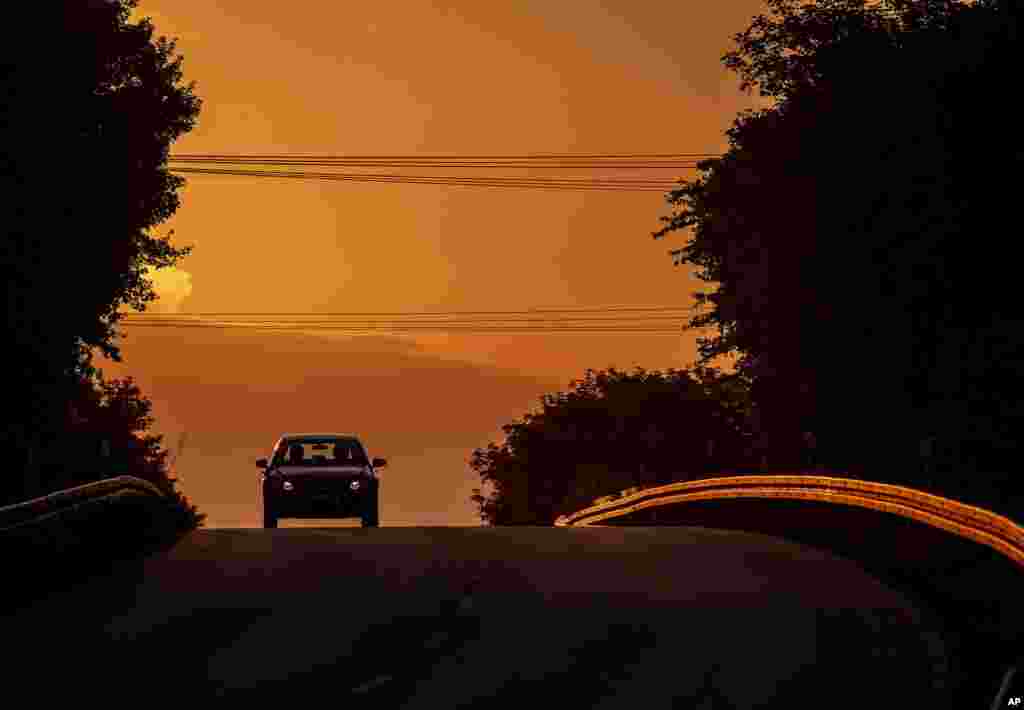 A car drives along a road as the sun rises in Frankfurt, Germany.