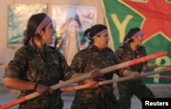 FILE - Kurdish female fighters of the Women's Protection Unit (YPJ) participate in training at a military camp in Ras al-Ain city in Syria's Hasakah province June 30, 2014.