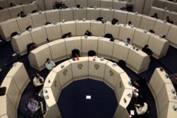 FILE - Stockbrokers work at the Tehran Stock Exchange in Iran, May 10, 2020.