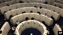 FILE - Stockbrokers work at the Tehran Stock Exchange in Iran, May 10, 2020.
