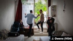 Ammar Othman (second from left) and his family moved into their new home two months ago. It was offered to them rent-free by Adonis Tsangouris (third from left), whose family own the building.