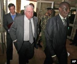 FILE - Jerome Corsi, center, who wrote "The Obama Nation: Leftist Politics and the Cult of Personality, follows an immigration department officer holding his passport.