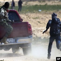 Libyan rebels run to take cover as mortars from Moammar Gadhafi's forces are fired on them on the frontline near Zwitina, the outskirts of the city of Ajdabiya, south of Benghazi, eastern Libya, Mar 23 2011
