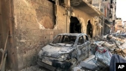 FILE - Rubble lines a street in Douma, the site of a suspected chemical weapons attack, near Damascus, Syria, April 16, 2018.