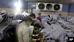 People identify the body of a relative, who was killed in Friday's plane crash, at a morgue in Karachi, Pakistan, May 23, 2020. 