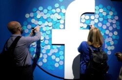 រូបឯកសារ៖ អ្នកចូលរួមបិទកំណត់ត្រាលើបដាមួយ ក្នុងសន្និសីទមួួយស្តីអំពីបច្ចេកវិទ្យាគ្រប់គ្រងទិន្នន័យដោយក្រុមហ៊ុន Facebook នៅទីក្រុង San Jose រដ្ឋកាលីហ្វ័រញ៉ា កាលពីថ្ងៃទី ១៩ ខែមេសា ឆ្នាំ ២០១៩។