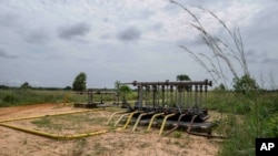 Pipes extend from an oil drilling structure near the village of Kinkazi, outside Moanda, Democratic Republic of the Congo, Sunday, Dec. 24, 2023. (AP Photo/Mosa'ab Elshamy)