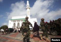 FILE - Soldiers serving in the African Union Mission in Somalia (AMISOM) patrol outside a Mosque during Eid al-Fitr prayers, marking the end of the fasting month of Ramadan at a Mosque in Somalia's capital Mogadishu, July 17, 2015.