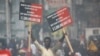 A protester holds placards during a march to demand an investigation into what they say is the alleged misuse of Venezuela-sponsored PetroCaribe funds, in Port-au-Prince, Haiti, Oct. 17, 2018.