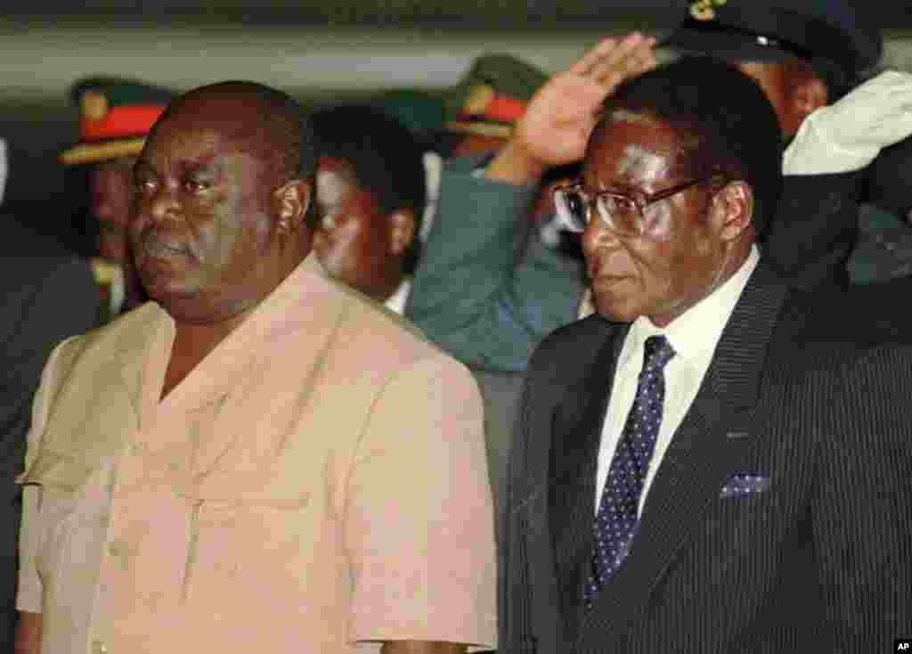 President Laurent Kabila of the Democratic Republic of Congo, left, is met at the Harare International Airport, June 1, 1997, by Zimbabwean President Robert Mugabe.