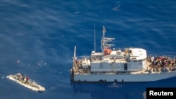 FILE - An aerial view shows a Libyan coast guard ship with migrants on deck, in a search and rescue zone off Libya's coast, May 11, 2019, as seen from Germany's Sea-Watch humanitarian organization's Moonbird aircraft. 