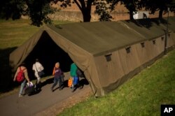 Migrants walk into a makeshift camp after registration in Bad Radkersburg, Austria, about 210 kms (130 miles) south of Vienna, Austria, Sept. 21, 2015.