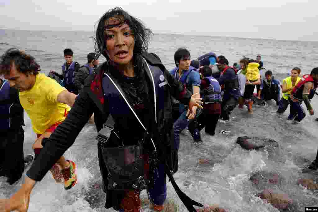 An exhausted Afghan migrant frantically looks for her children as she arrives on the Greek island of Lesbos in an overcrowded dinghy after crossing a part of the Aegean Sea from the Turkish coast.