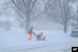 A man is bundled up against bitter wind and blowing snow as he operates a snowblower, Jan. 30, 2019, in Buffalo, N.Y. The area received more than a foot of snow since Tuesday and was under a blizzard warning.