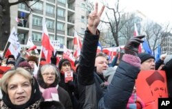 FILE - Protesters shout slogans during an anti-government demonstration in front of the Constitutional Court, in Warsaw, Poland, Dec. 18, 2016.