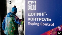 A man walks past a sign reading doping control, at the Laura biathlon and cross-country ski center, at the 2014 Winter Olympics in Krasnaya Polyana, Russia, Feb. 21, 2014.