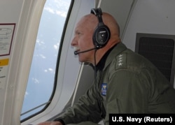 FILE - Adm. Scott Swift, commander of the U.S. Pacific Fleet, observes operations aboard a P-8A Poseidon aircraft during a flight hosted by the Pelicans of Patrol Squadron (VP) 45 in the South China Sea, July 18, 2015.