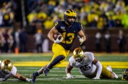 FILE - Michigan running back Tru Wilson rushes 27 yards for a touchdown in an NCAA college football game against Notre Dame in Ann Arbor, Michigan, October 26, 2019.