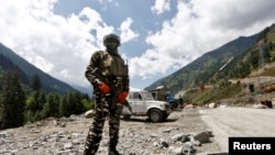 FILE - An Indian Central Reserve Police Force (CRPF) member stands guard at a checkpoint along a highway leading to Ladakh, at Gagangeer, in Kashmir's Ganderbal district, Sept. 2, 2020.