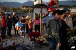 Yanira Perez (2-R) wipes her eyes as she and her mother, Marcela, pay respects at a makeshift memorial to honor the victims of Wednesday's shooting rampage, Dec. 5, 2015, in San Bernardino, California.