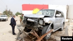Iraqi Kurdish security forces stand next to the car of Mohammed Younis, a senior official of Iraq's state-run North Gas Company (NGC) who was killed by gunmen, in the northern oil city of Kirkuk, Iraq, May 2, 2017.