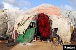 A Somali woman walks out from her makeshift shelter at a camp for the internally displaced people outside Mogadishu, Somalia August 28, 2018.