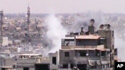 This image made from amateur video purports to show smoke rising from buildings in Homs, Syria. Syrian forces renewed shelling of the central city of Homs on Monday, one day after the head of the U.N. observers' mission demanded that warring parties allow