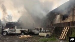 In this image from video, smoke envelopes a building as emergency services attend an early-morning fire in Congo's capital Kinshasa, Thursday Dec. 13, 2018, which is reported to have destroyed thousands of voting machines just 10-days before the upcoming presidential election. 