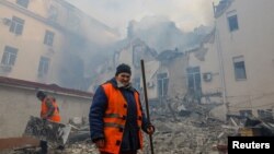 Municipal workers remove debris outside a local railway administration headquarters damaged in shelling in the course of Russia-Ukraine conflict in Donetsk, Russian-controlled Ukraine, Nov. 7, 2022. 