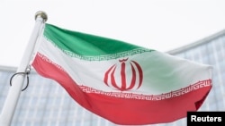 FILE - The flag of Iran waves in front of the the International Center building housing the headquarters of the International Atomic Energy Agency, in Vienna, Austria, May 24, 2021.