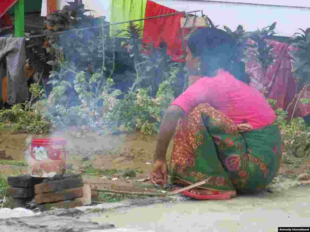 Rohingya woman cooking in Aceh.