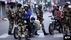 Security personnel question motorists on a street in Jammu on August 5, 2019. (Photo by Rakesh BAKSHI / AFP)